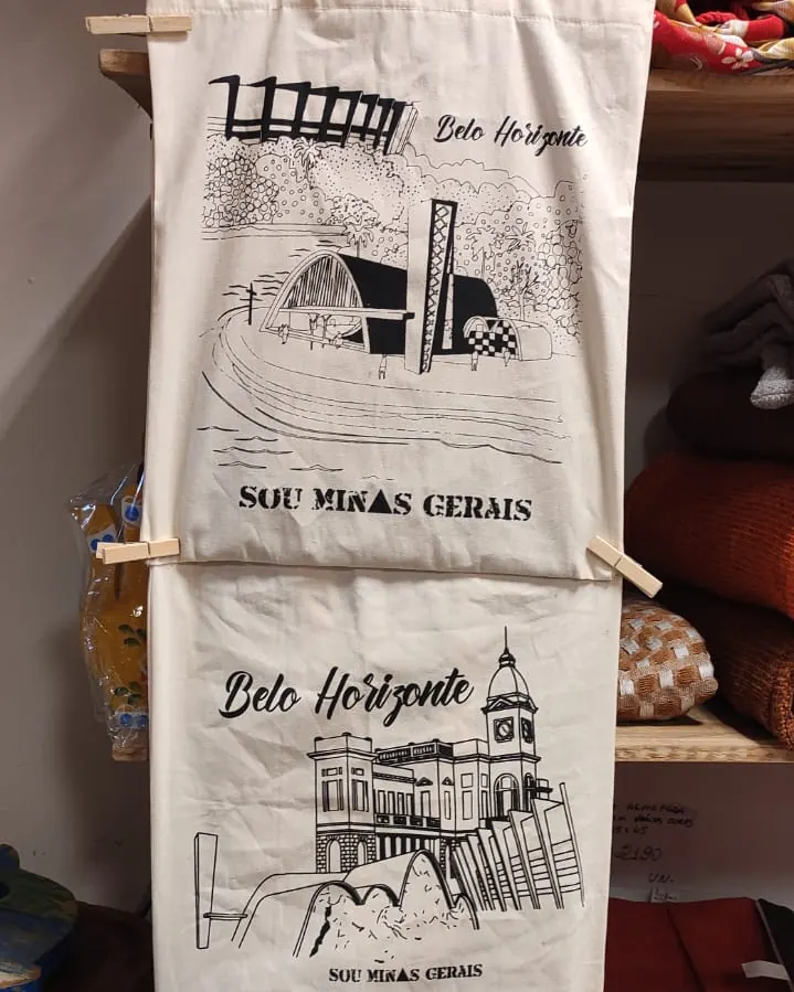 Panos de prato pendurados com desenhos de Belo Horizonte e a frase Sou Minas Gerais