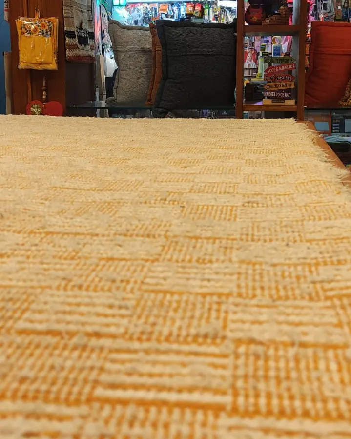 Tapete amarelo de trama grossa estendido no corredor da loja